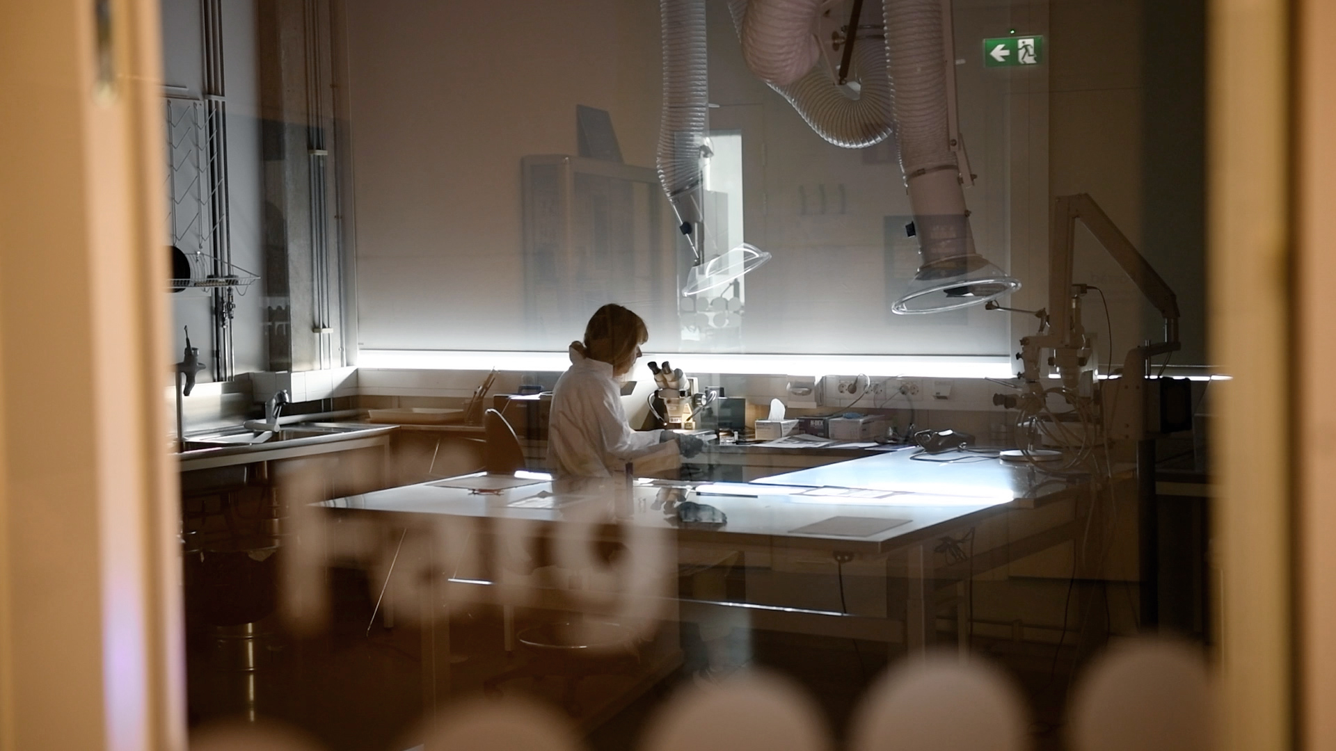 En kvinna sitter i laboratoriemiljö iklädd vit rock.