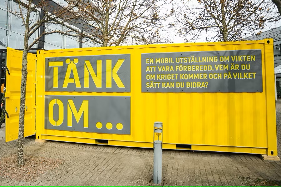 En gul container med grå text på